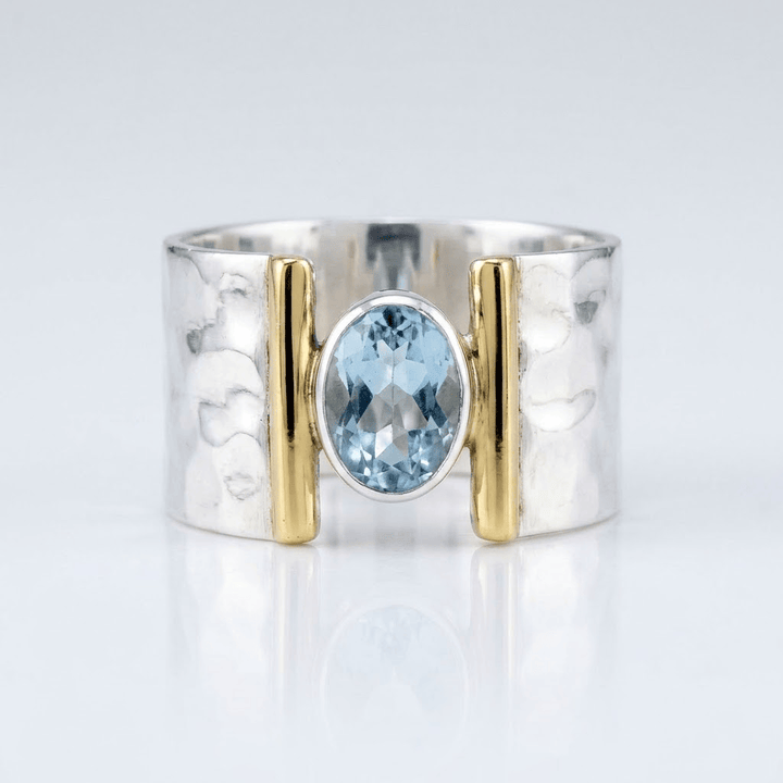 Moderner Ring aus Silber, Gold und Topas mit elegantem Design, von der Marke Rose & Oliver, der Details des Schmuckstücks zeigt.
